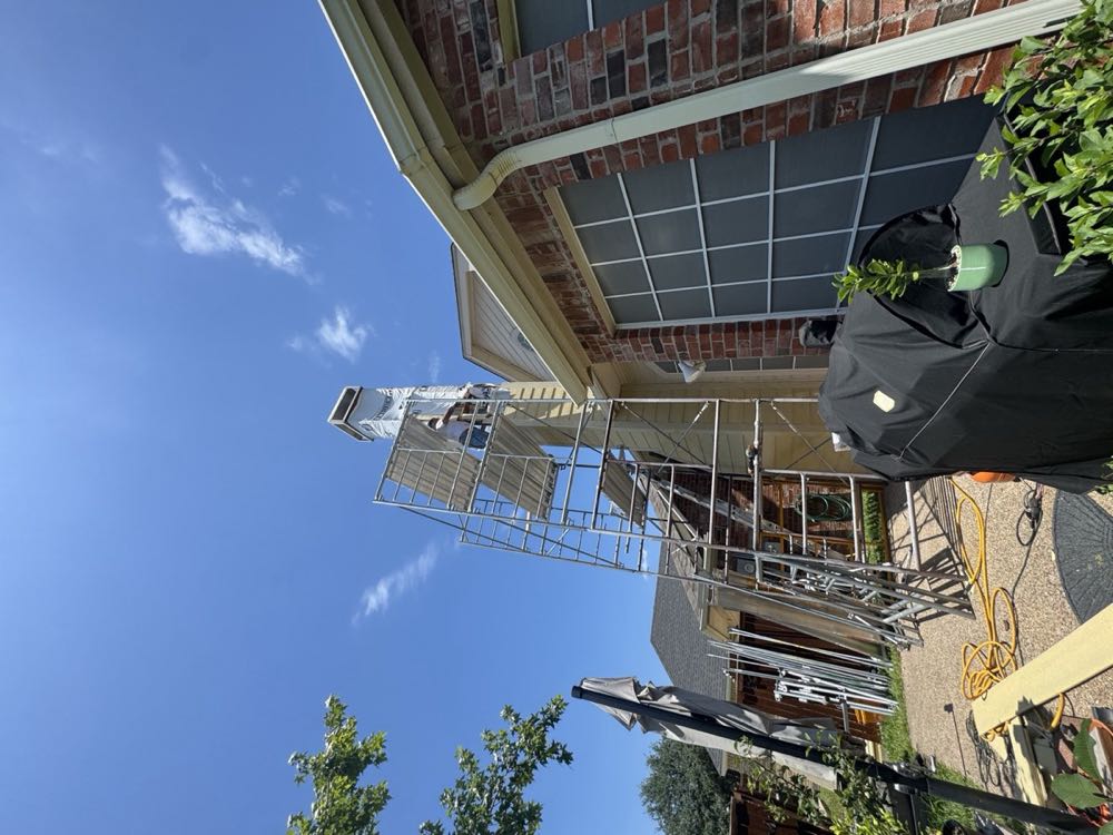 Texan Flue technician installing a chimney chase on scaffolding in Dallas–Fort Worth
