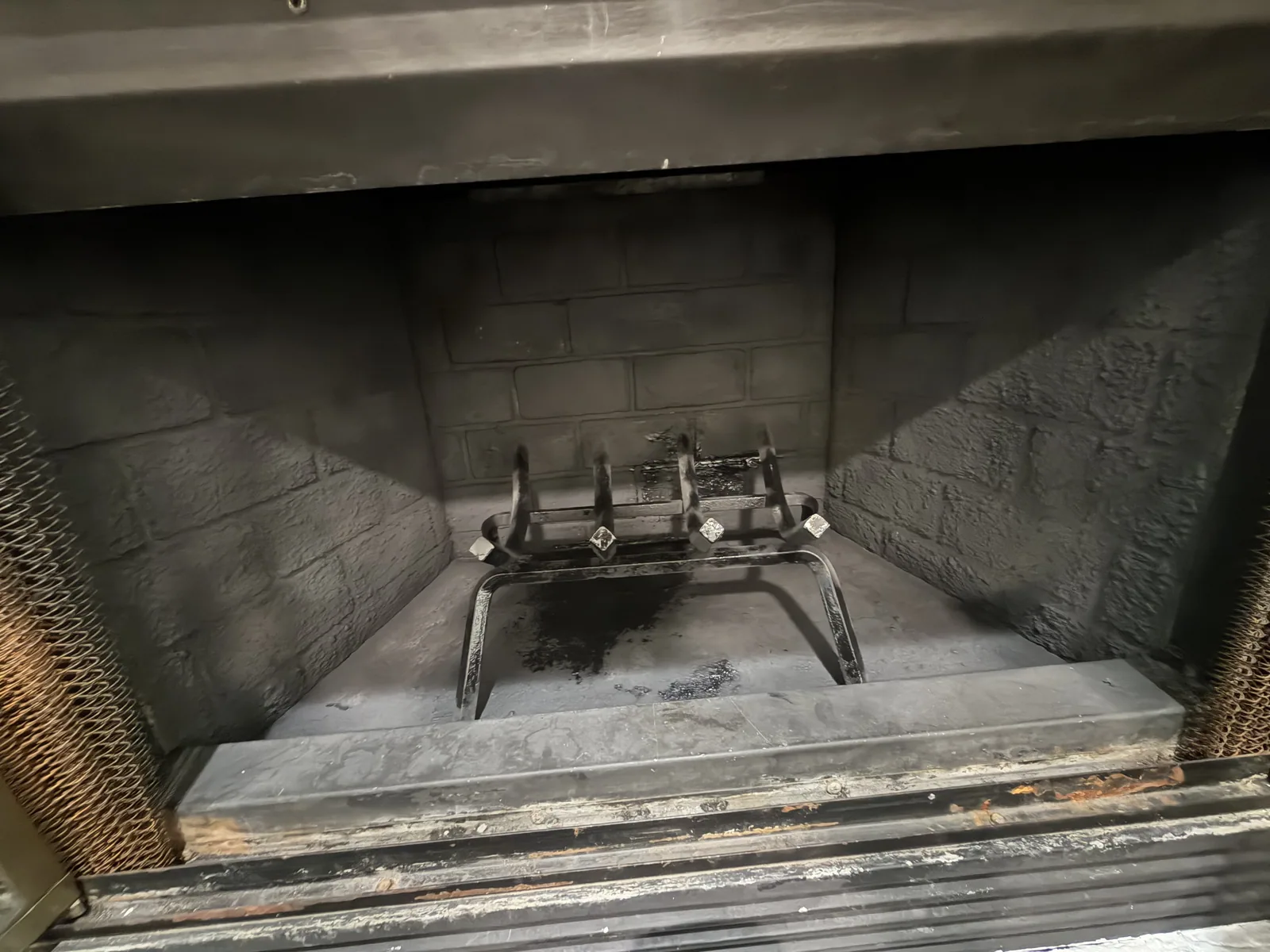 Sooty firebox and grate before a chimney sweep in DFW
