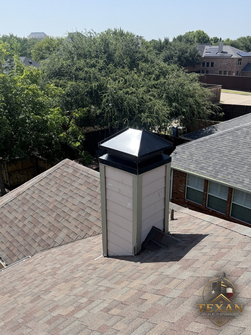 Finished black chase cover precision-fitted on a DFW chimney chase — Texan Flue, Dallas–Fort Worth