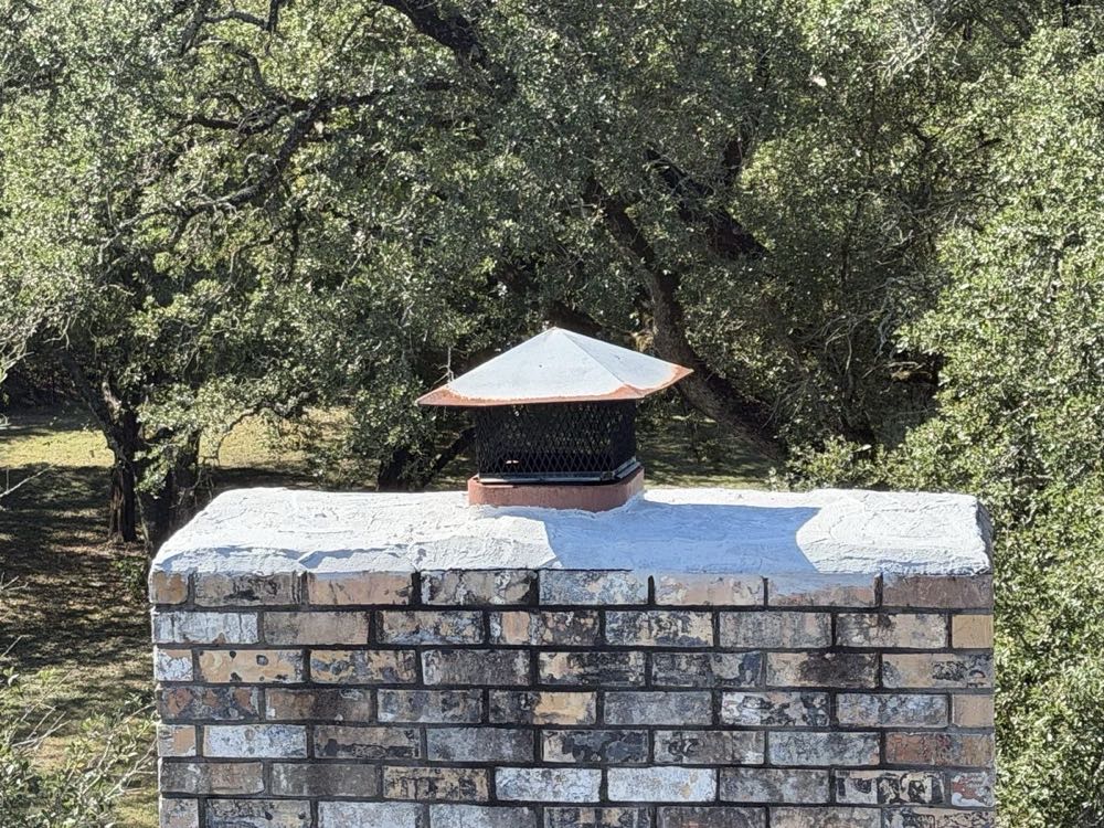 Stone chimney with rain cap after waterproofing treatment in Dallas–Fort Worth