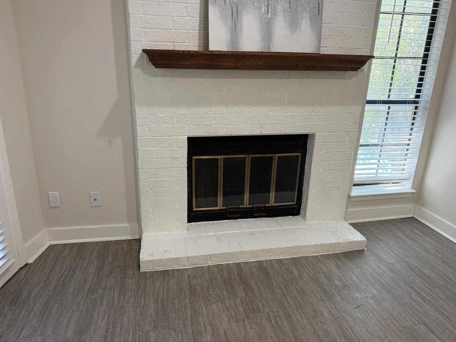 Finished white brick fireplace with glass doors after service